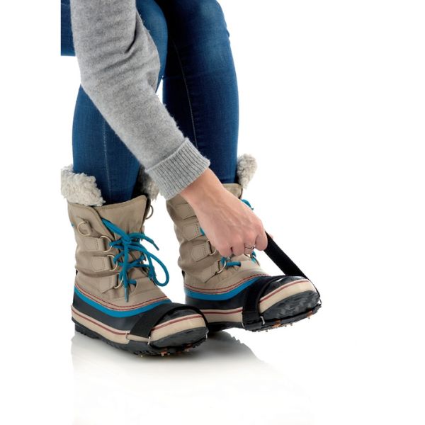 Person putting on a pair of Sidas Walk Traction Snow and Ice Grippers with blue laces on a white background