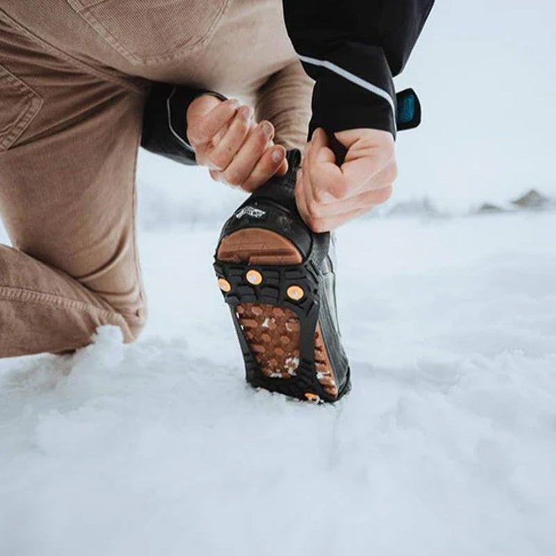Person adjusting Sidas Walk Traction Snow and Ice Grippers  in the snow